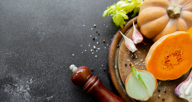 蔬菜:橙汁、大蒜、洋葱。香料研磨机，胡椒，盐。黑色背景。本空间图片下载