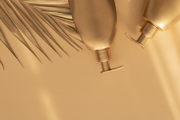 金色干净的化妆品瓶子，棕褐色的背景棕榈金色的叶子。化妆品模拟瓶子，管。品牌产品、水疗、美夏背景平铺俯视图复制空间。你设计的地方图片下载