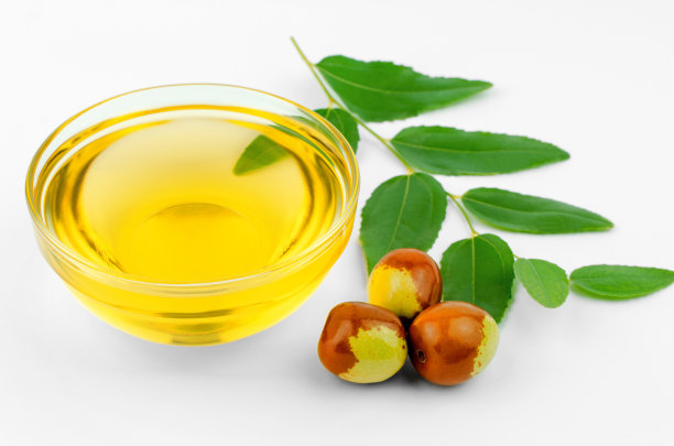 碗里放荷荷巴油，成熟的果实和白色的绿叶图片下载