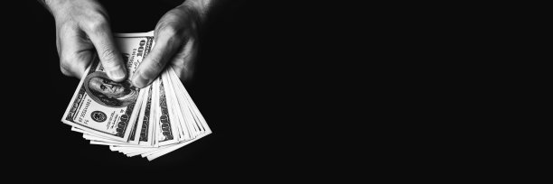 男性手里拿着我们百元钞票的横幅图片下载