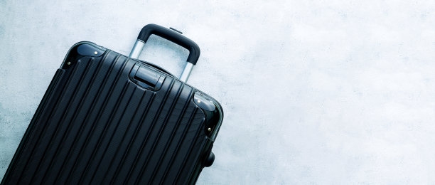 黑色旅行袋，黑色行李箱设置在黑色背景，俯视图图像，平面布局。旅行极简概念，黑色与黑色经典的行李模型，大小不一。旅行箱配件套装，旅行理念。图片下载