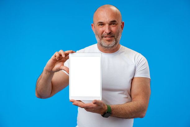 幸福的白人中年男子显示平板电脑屏幕上的蓝色背景图片下载