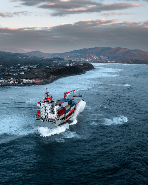 在波涛汹涌的海上运输货物的集装箱船图片下载