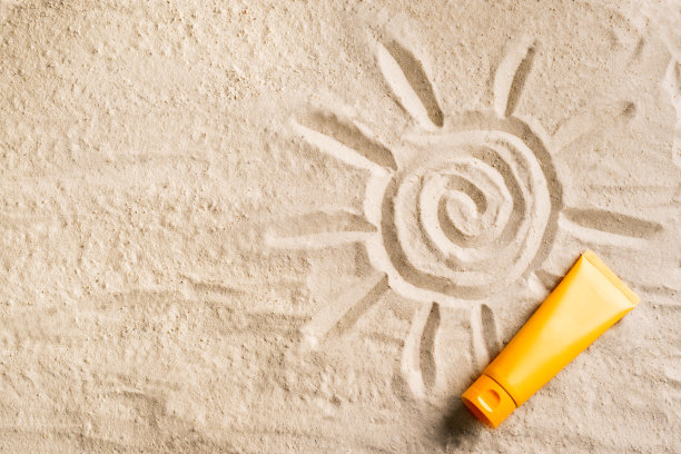 在沙滩上涂抹防晒霜图片下载