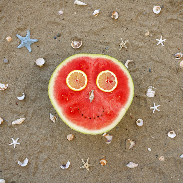 西瓜一半放在沙滩上图片下载