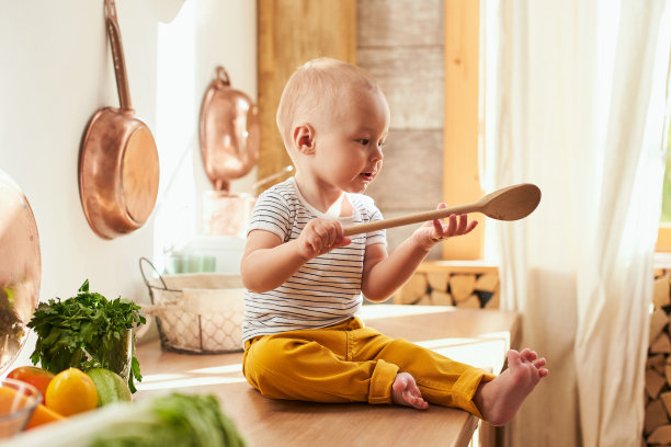 一个小男孩在玩厨房用具。图片下载