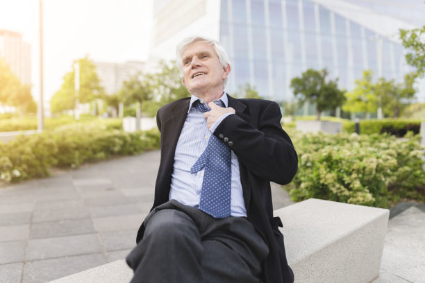 正在松开领带的年长商人，在城市里图片下载