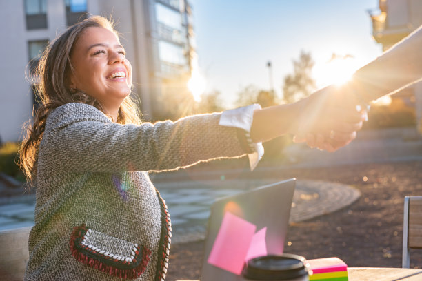 快乐的商业女性与不认识的同事握手图片下载
