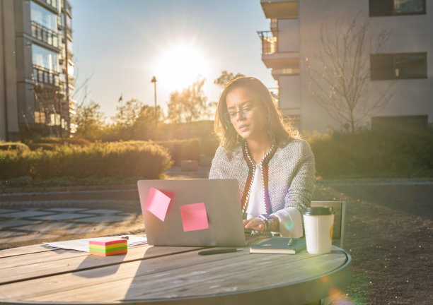 年轻的女商人在户外使用笔记本电脑图片下载