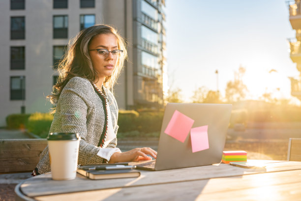 年轻的女商人在户外使用笔记本电脑图片下载