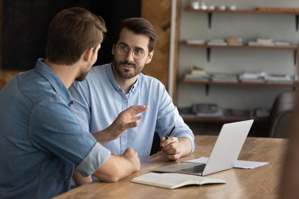 严肃的男性员工在办公室电脑前集思广益图片下载