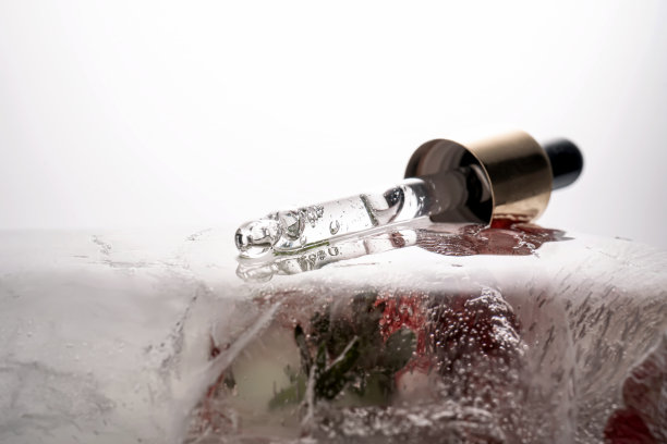 移液管放在一大块有冰冻花朵的冰上。图片下载