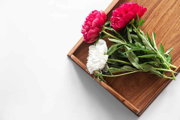 牡丹花束放在白色的木托盘上，平铺。图片下载