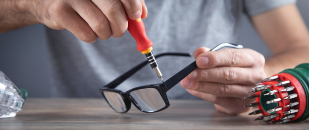 光学技师用螺丝刀修理眼镜。图片下载