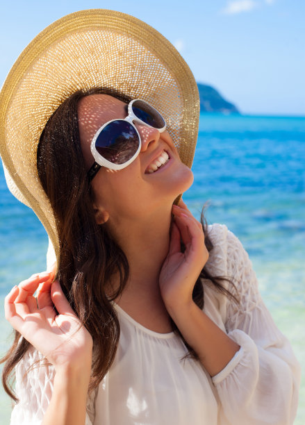 沙滩上戴着帽子的快乐女人图片下载