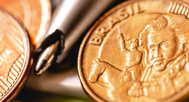 雷亚尔，来自巴西的钱。计算器上放着巴西硬币，还有一支坏掉的钢笔。微距摄影。巴西经济和通货膨胀的概念。图片下载