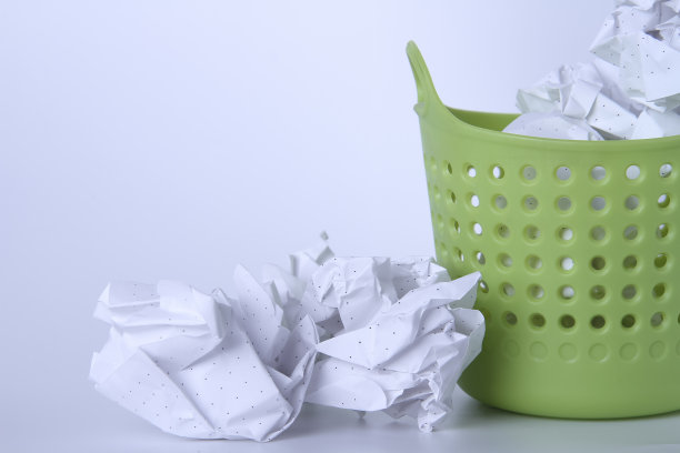 绿色的垃圾桶。完整的篮子里。放在篮子里的皱巴巴的纸。100%了。图片下载
