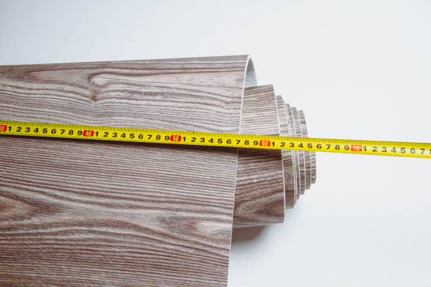 切割用油毡的测量。人削减油毡。卷尺和卷尺用于标记。图片下载