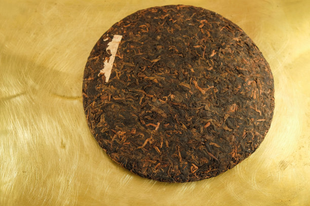 中国云南普洱茶饼。黄金的背景。图片下载