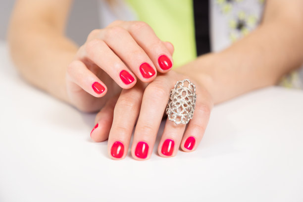 美丽的女性手与粉红色明亮的美甲和珍贵的戒指在她的手指上。特写镜头。沙龙美甲的概念图片下载