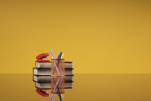 学校用品作为一种回归学校的概念。书刊订书机和彩色铅笔作为背景，自由空间的学校，研究所，大学网站，学校教育的文章图片下载