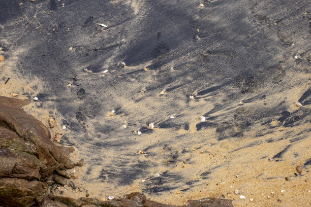 黑色沙滩与普通沙子混合海水。图片下载