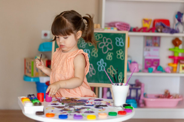 女孩(蹒跚学步的孩子)正在选择水彩画图片下载