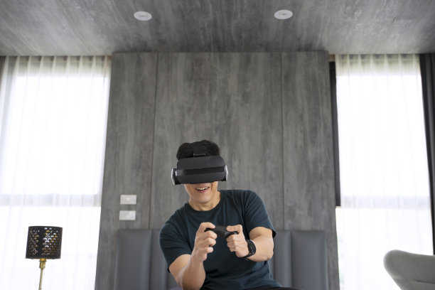 一名男子在卧室里使用虚拟眼镜。图片下载