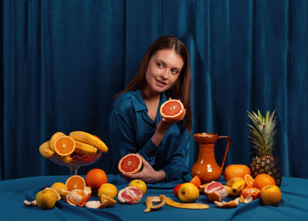 拿着水果的女人，蓝色背景图片下载