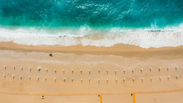 在土耳其风景优美的绿松石海滩上，男女日光浴的鸟瞰图图片下载