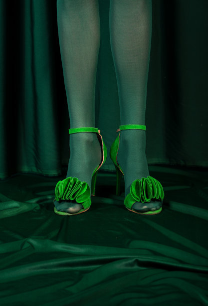 鞋和腿在深绿色的花朵窗帘图片下载