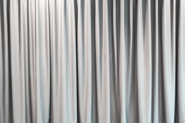 浅灰色窗帘背景壁纸。抽象白色织物纹理装饰。豪华垂直清洁和光滑的布背景。家庭内部。图片下载