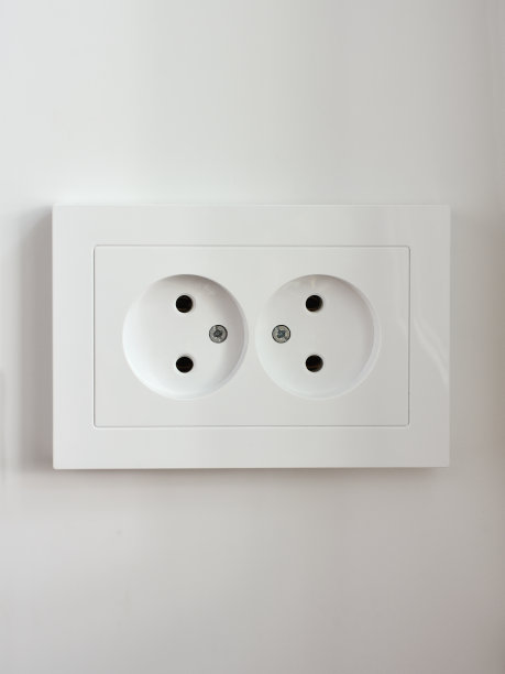 插座为两个白色的针脚在一个浅色的墙壁上，特写图片下载