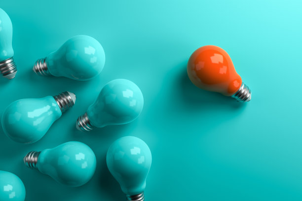 在绿松石色的背景下，橙色的灯从其他灯中脱颖而出。图片下载