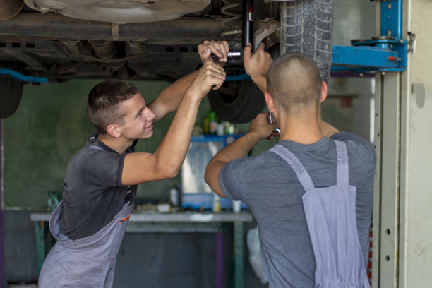 青少年正在更换汽车减震器。图片下载