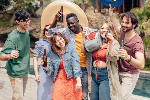 夏天，一群朋友在泳池边欢笑、跳舞、玩乐图片下载