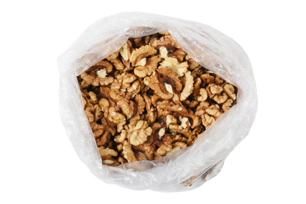 在白色背景上隔离的塑胶袋内剥去核桃仁(剪径)图片下载
