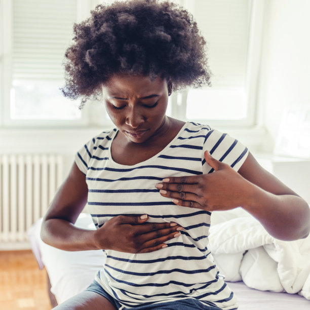 年轻女性在做乳房自检。一名年轻的非洲妇女自己摸着自己的乳房说她很担心乳腺癌。保健和乳腺癌的概念。乳腺癌检查指南。图片下载