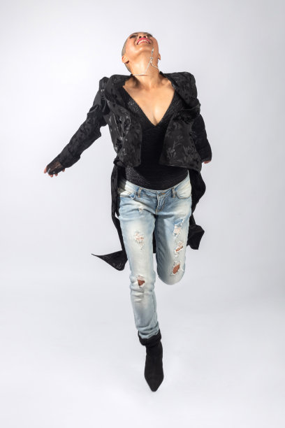快乐的泰国女人穿着深色衣服和牛仔裤在空中跳跃图片下载
