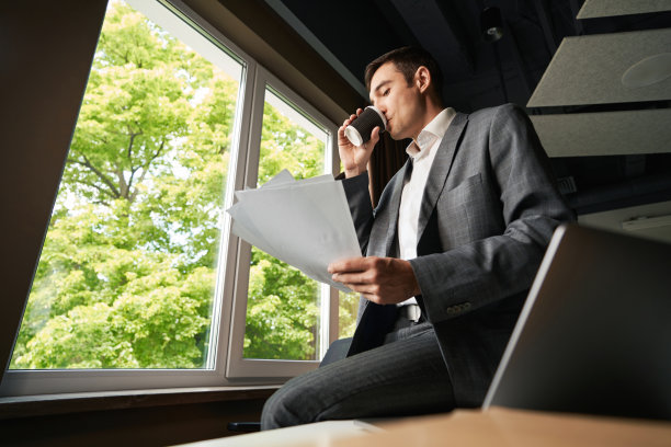 办公室职员一边喝咖啡，一边查看文件图片下载