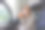 一名成年女子开着车门坐在车里，一边沉思一边用旅行杯喝着咖啡。图片下载