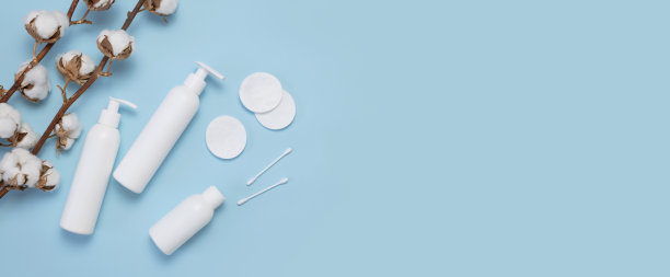 天然有机美容产品概念。白色化妆瓶容器，棉枝，棉垫，用于卫生的耳棒，蓝色背景俯视图平铺。化妆品SPA品牌模型图片下载
