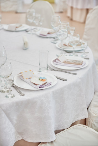 餐桌设置与盘子，白色餐巾和餐具在桌子上，复制空间。婚宴上的餐具。餐厅里的婚宴用的桌子图片下载