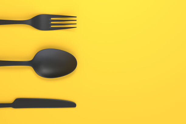 叉子，勺子和刀在黄色的背景图片下载