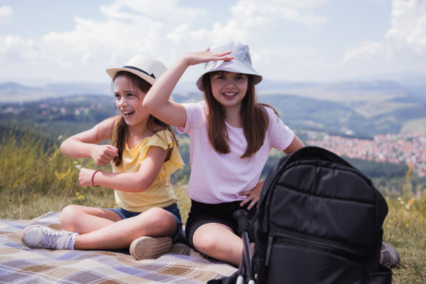 快乐的女孩们坐在野餐毯子上跳舞图片下载