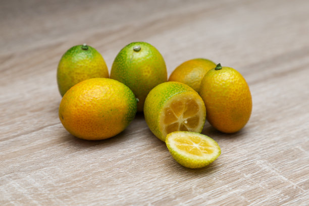 金桔或金桔和长叶，半孤立在木质背景上图片下载