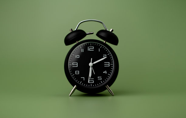 黑色闹钟设置在深绿色背景图片下载