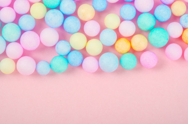 泡沫珠子的各种颜色鲜艳的粉红色粉彩背景与空白。图片下载