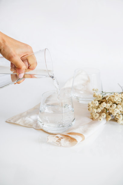 盛有白底天然水的玻璃杯。极简主义的形象。图片下载