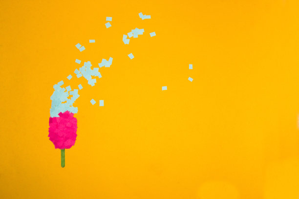 粉蓝色的纸冰淇淋在黄色的背景上，冰淇淋飞溅，创意夏季概念与拷贝空间图片下载